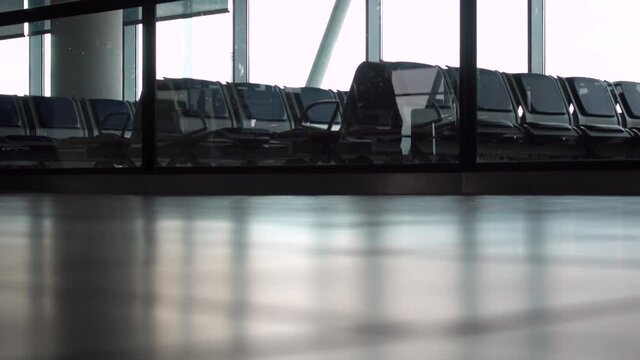 4K ground level video clip of anonymous people walking through an airport terminal with suitcases, bags and baggage