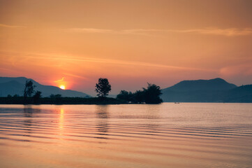 Fototapeta na wymiar Sunrise over mountain range on Lam Taphoen reservoir in countryside