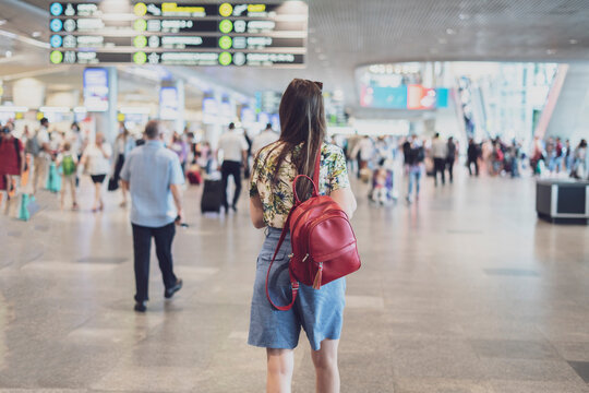 young woman walking in the airport terminal to the airplane flight