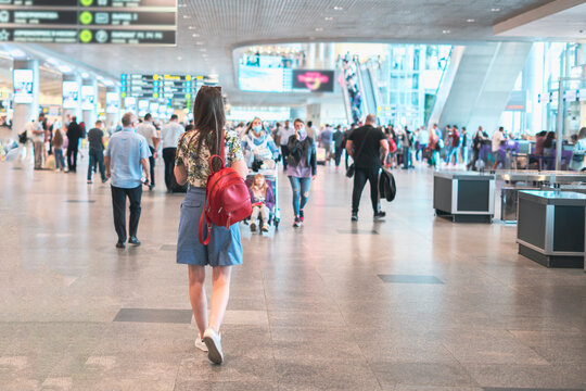 young woman walking in the airport terminal to the airplane flight