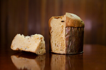 Panettone slice on the table. Panettone cut on wooden table and textured background. Panettone concept. Chocotone concept.
