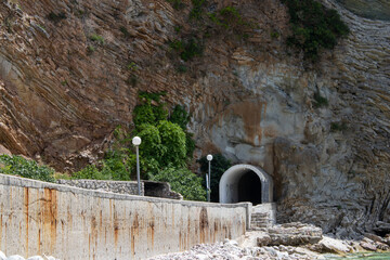 Tunnel in the rock. Mountain road near the seashore. Way in the dark.