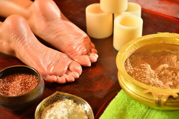 Ayurvedic foot massage with oil on the wooden table in traditional style. Top view.