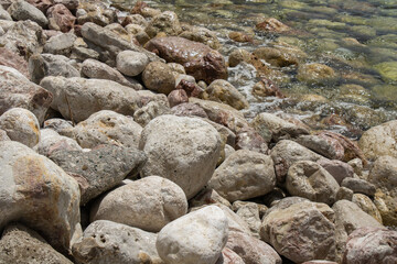 Group of large gray stones. Boulders are standing in the beautiful water. Rocky seaside coast. Wallpaper - sea and rocks met.