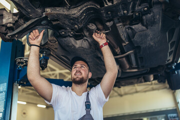 Fototapeta na wymiar Portrait of a mechanic repairing a car in his garage