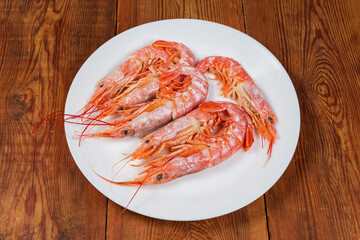 Boiled Argentinian red shrimps on dish on rustic table
