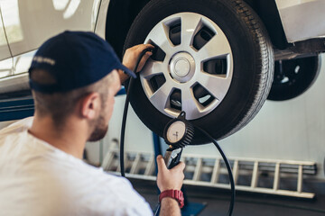 Mechanician changing car wheel in auto repair shop © Mediteraneo