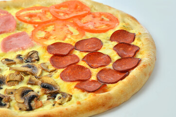 assorted pizza with ham onion and tomato cheese closeup view