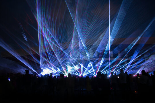 blue laser lights and people silhouettes at concert