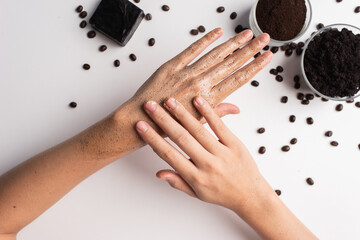 Young woman hand applying soap coffee grounds scrub massaging cosmetic skincare. Scrub exfoliates...