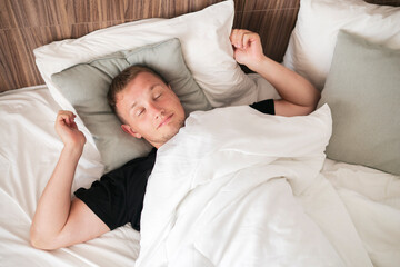 man waking up in the morning, stretching the body and open eyes