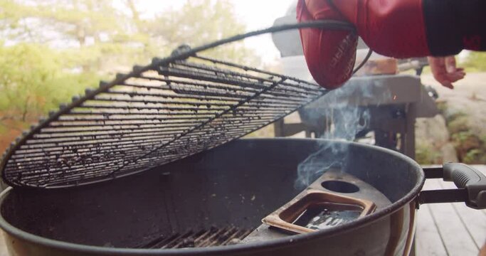 A rack of dry rubbed ribs being slow cooked and smoked on a kettle grill barbecue