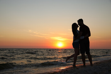Couple spending time together on beach at sunset