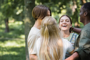 African american teenager embracing friends in park