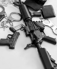 Black and white of Modern automatic rifle , Silver police handcuffs, wallet, semi automatic handgun...
