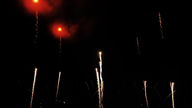4K  fireworks background. New year's eve fireworks celebration. real golden shining fireworks display with bokeh lights in the night sky. glowing fireworks show. 