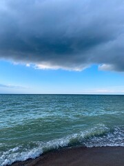 Big dark cloud in the blue sky at the seaside, sea horizon, natural sea background