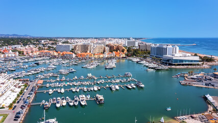 Fototapeta na wymiar A view from the sky of the tourist Portuguese town of Vilamoura, with Yachts and sailboats moored in the port on the dock.