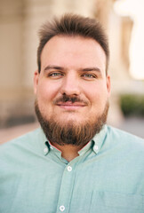 Fototapeta premium Portrait of a young millennial bearded man on city streets