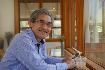an elderly retired man smile sitting and relaxing casually in the coffee shop