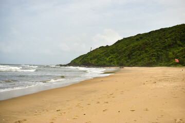Fototapeta na wymiar Ocean-Sea Waves Beach Sand and Mountains Yellow Landscape Background