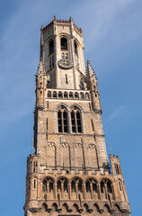 Brugge, Flanders, Belgium - August 4, 2021: Brown brick top half of Halletoren as part of Belfry against blue sky.