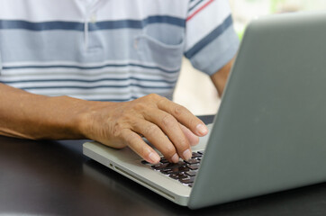 man hand using computer laptop on table at home