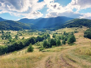 Obraz premium Beautiful mountain landscape, with trees, hills and blue sky with clouds. Trascau mountains, Transylvania, Romania.