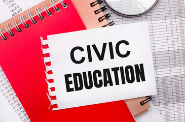 On a light background - reports, a magnifying glass, brown and red notepads, and a white notepad with the text CIVIC EDUCATION. Business concept