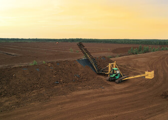 Peat extraction site. Harvester at collecting peat on peatlands. Mining and harvesting peatland....