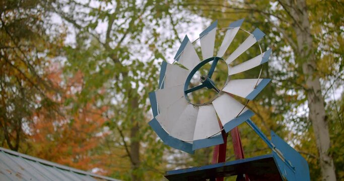 Lock off shot looking up at a weathervane slowly spinning on a dreary breezy autumn day