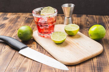 Making a red cocktail with lime and ice.