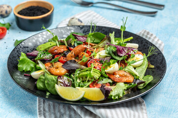 Fresh salad bowl with cherry tomatoes, cucumber, avocado, eggs and smoked shrimps, mixed greens. Healthy food. Clean eating. place for text
