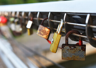 Padlock on Lovers Lock Bridge. Husband and wife during the wedding hung a padlock on the fence on metal grate. Love locks concept. Many a padlock are locked with a key for the happiness of people