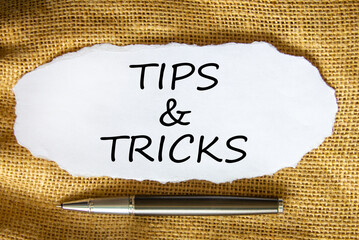 Tips and tricks symbol. Words 'Tips and tricks' on white paper. Black metallic pen. Beautiful...