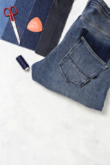 Handicraft, clothing repair. Ripped blue jeans sewing accessories