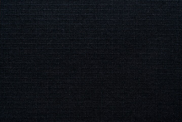 Textile. The material is gray or black in a small check. Fabric background with small squares....