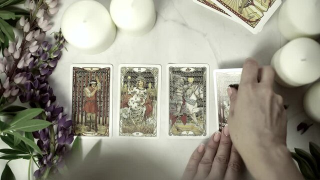 Blurred View of tarot card on the table, Fortune teller woman reading a future by tarot cards. Esoteric concept, fortune telling and predictions