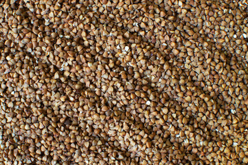 Dry buckwheat, raw grains. Texture. Healthy nutrition concept. Horizontal orientation. Buckwheat contains a large amount of vitamins and minerals. Top view.