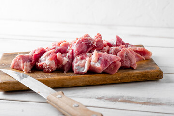 Sliced pieces of raw meat on a cutting board. Pork or beef is prepared for cooking.