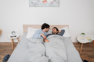 gay couple lying on bed in morning