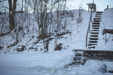 slippery snow cowered stairway on river bank
