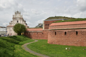 Mur bastionu i widok kościoła o białej elewacji - obrazy, fototapety, plakaty