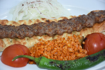 Turkish kebab with bulgur pilaf, roasted tomatoes, roasted peppers, onions and pita bread