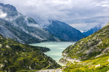Naklejka na ściany i meble clouds over Grimsel Pass and lake in Switzerland
