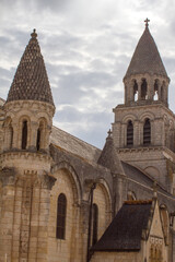Fototapeta na wymiar Notre Dame-La-Grande, Roman church over beautiful grey sky, France