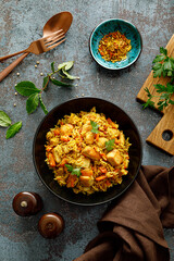 Pilaf or pilau with chicken, traditional uzbek hot dish of boiled rice, chicken meat, vegetables and spices on plate, top view.