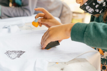 Obraz na płótnie Canvas Children's hands painting t-shirts.