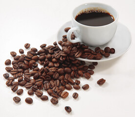 xícara de café com grão de café esparramado em fundo branco para recorte.