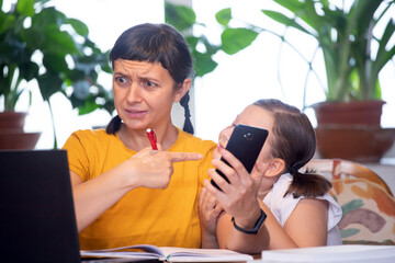 Mother working from home with kid. Children make noise and disturb woman at work.